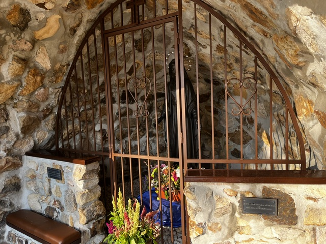 Inside the grotto gate, the statue of Our Lady of Grace with fresh flowers at her feet